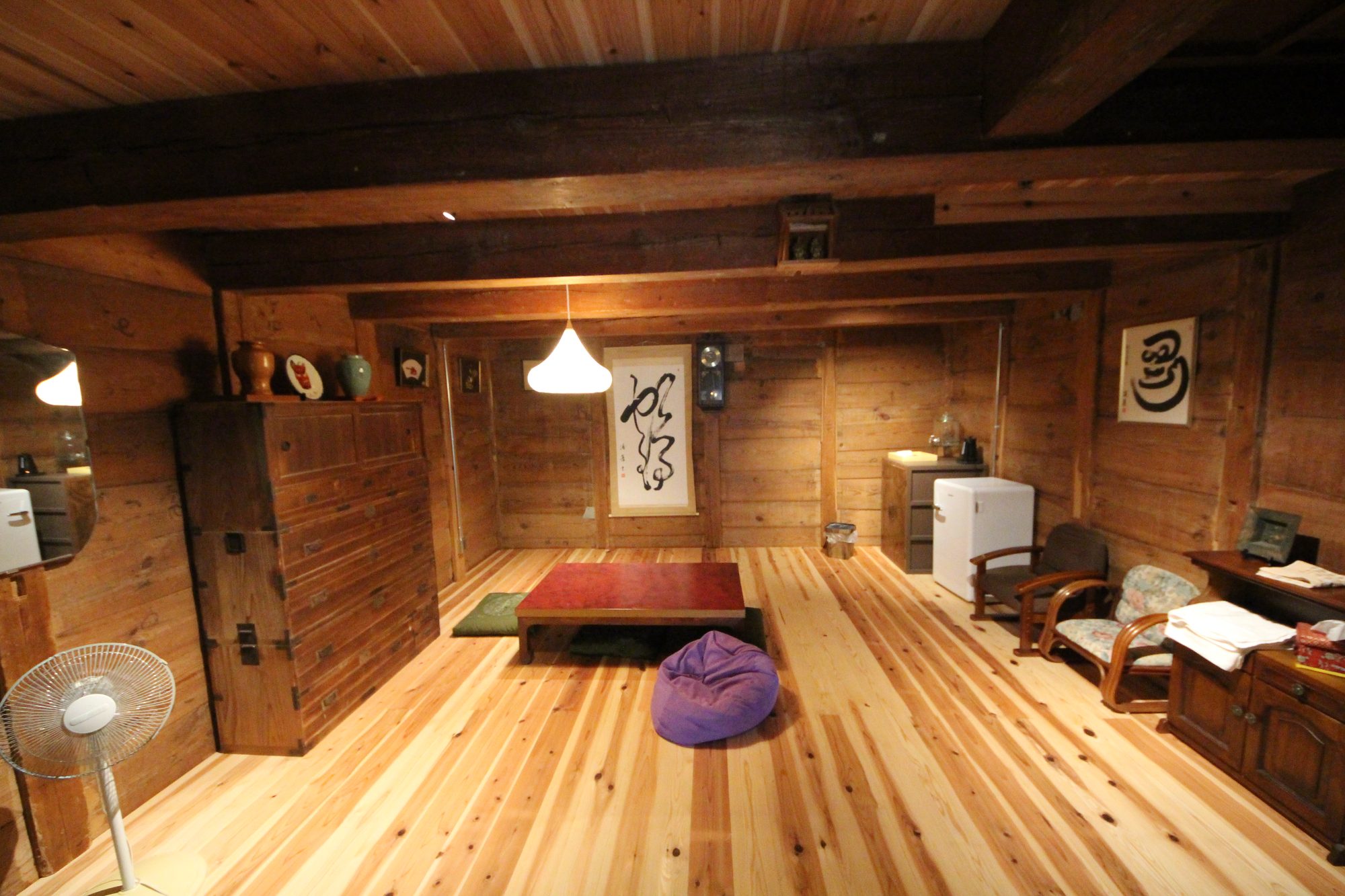 Downstairs living room with cedar walls, low table, and calligraphy