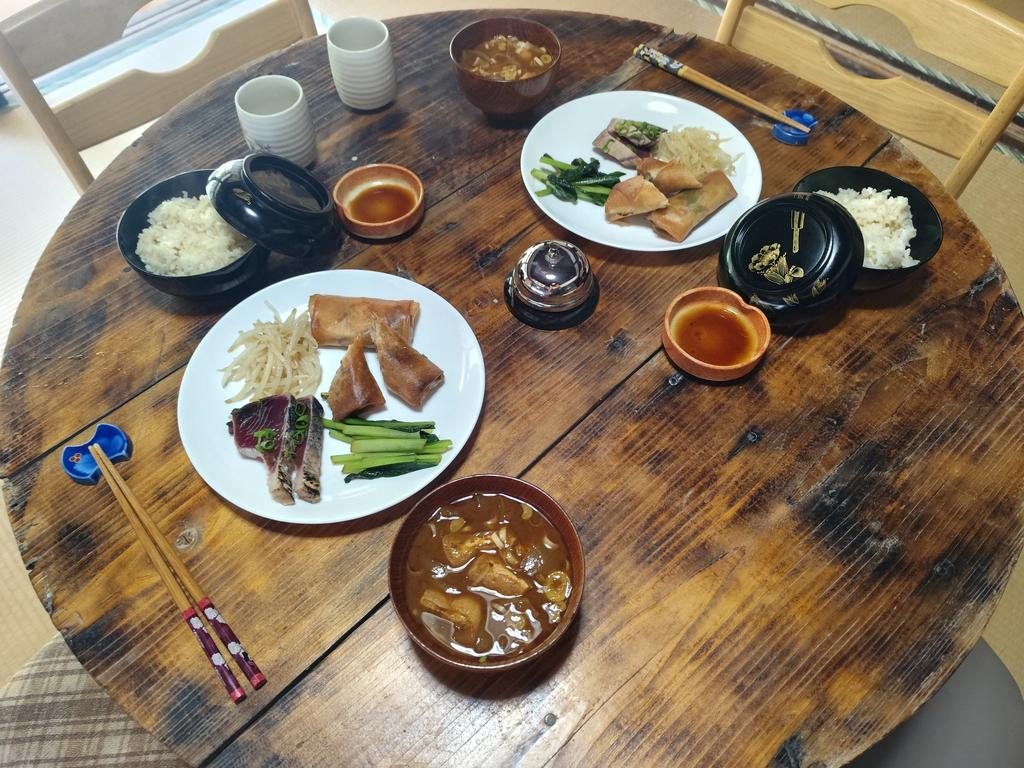 A Japanese meal set on the round wooden table in the Japan Rooms — rice, soup, and shared plates
