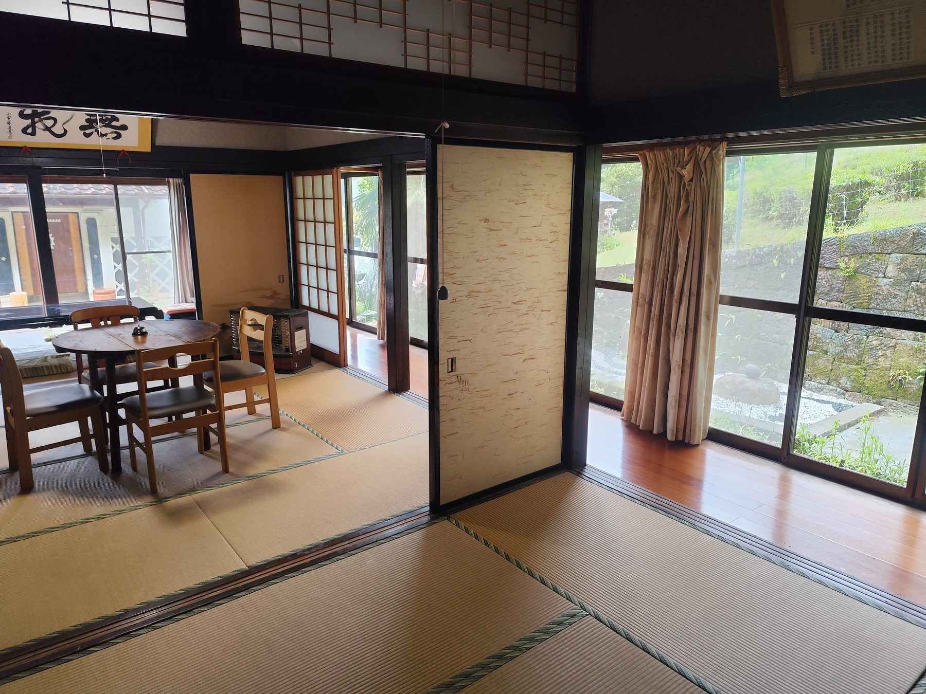 Japan Rooms in the main kominka: tatami, fusuma, and a wooden dining table looking onto the garden